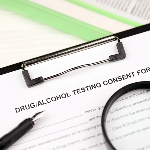 Drug and alcohol testing consent form on A4 tablet lies on office table with pen